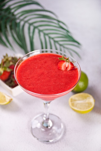 Cold strawberry margarita or daiquiri cocktail with lime and rum