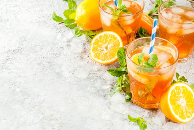 Cold summer drink. iced tea with lemon and mint on grey stone background. 