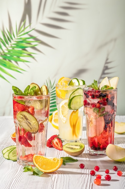 Cold summer fruit lemonade drinks, refreshment infused water. Summer drinks with ice.