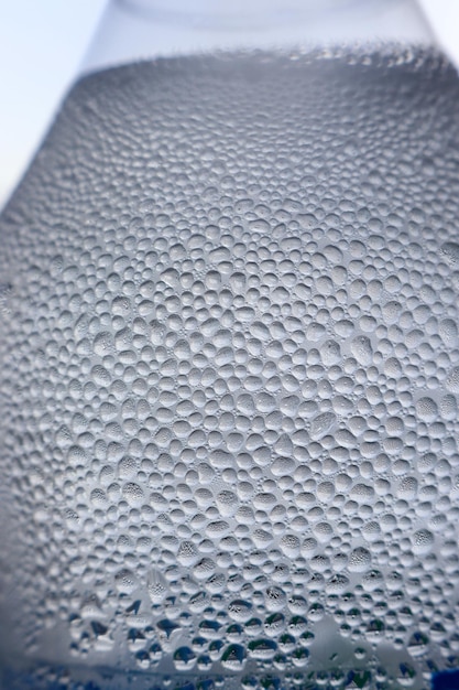 Cold surface of water bottle with sparkling bubbles macro shot