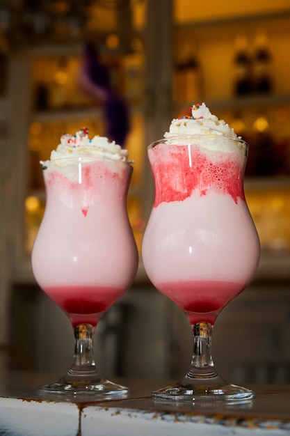 Cold sweet milkshake with red syrup and cream