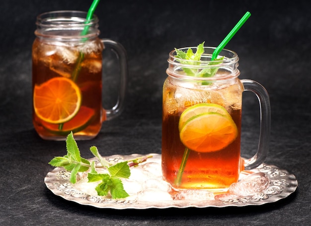 Cold tea with lime and fresh mint in glass jars