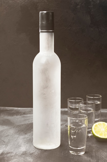 cold vodka in shot glasses on a black space. toned
