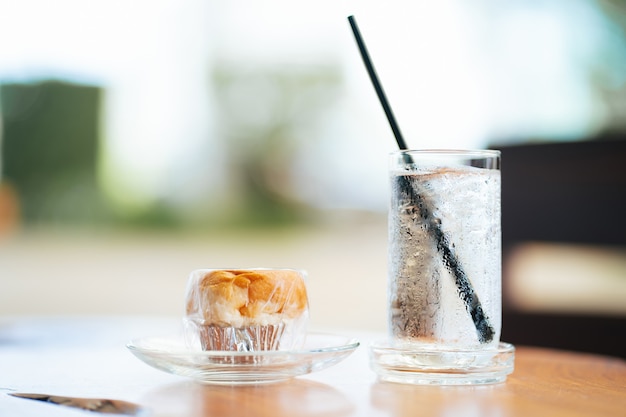 Acqua fredda in un bicchiere e pane per la colazione. messa a fuoco selettiva.