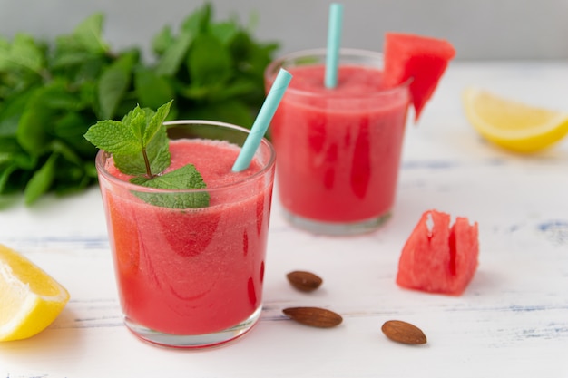 Foto frullato di anguria fredda con menta e limone in bicchieri. un cocktail di succo di anguria