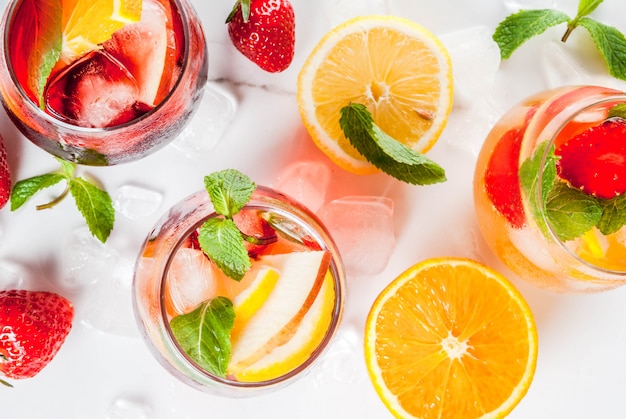 Cold white, pink and red sangria cocktails with fresh fruits, berries and mint