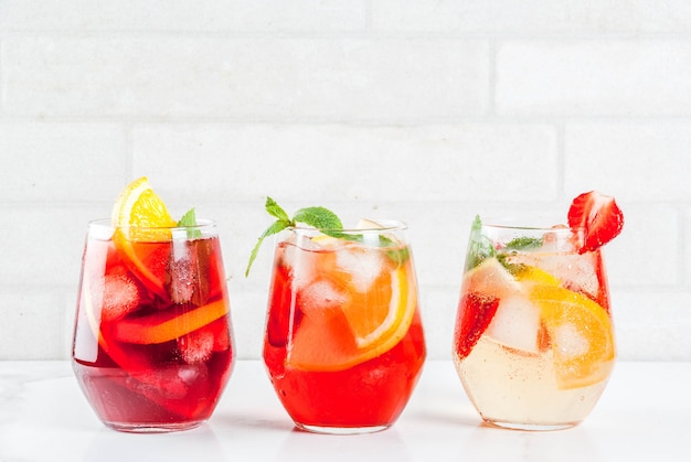 Cold white pink and red sangria cocktails with fresh fruits berries and mint.