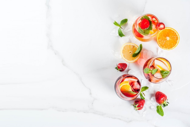 Cold white pink and red sangria cocktails with fresh fruits berries and mint. above