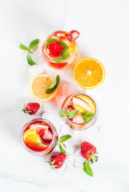 Freddo bianco rosa e rosso cocktail sangria con frutti di bosco freschi e menta.