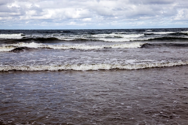 Tempo freddo e ventoso in agosto, costa del mare con molte onde da tempo ventoso, mar baltico in estate