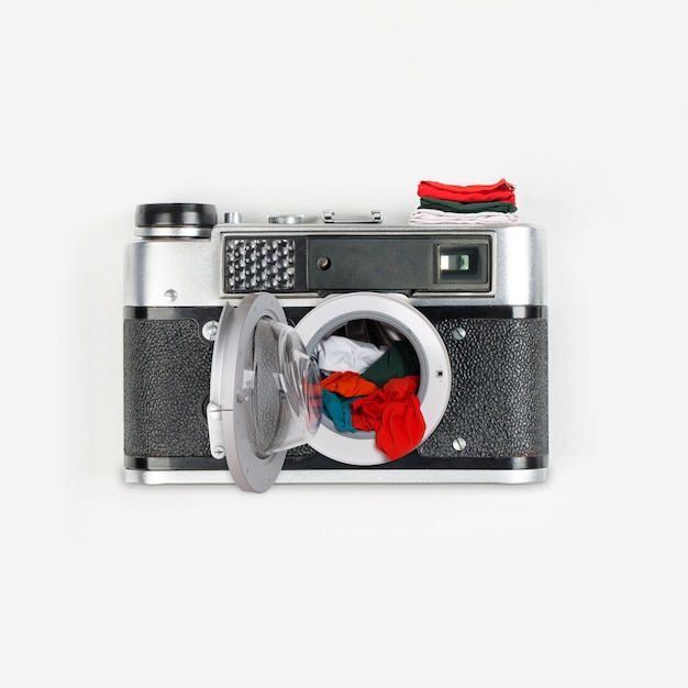 Collage made out of vintage camera and washing machine with clothes