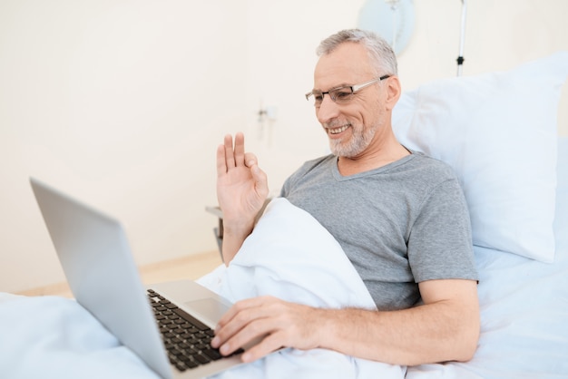 Пациент реабилитации коллаж использует ноутбук в постели