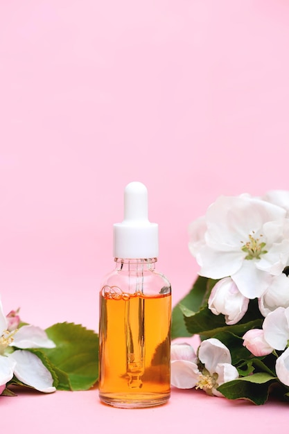 Collagen facial oil in a glass dropper bottle on a pink background vertical photo