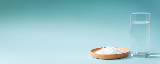 Collagen powder and glass of pure water on blue background