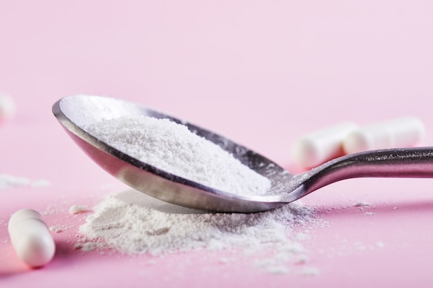 Collagen powder and pills on spoons