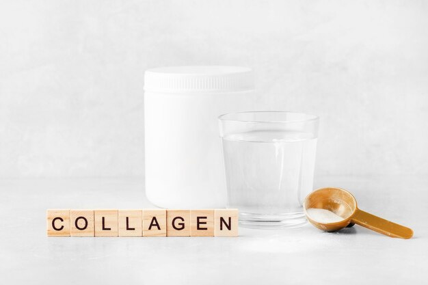 collagen powder with a glass of water on a gray background