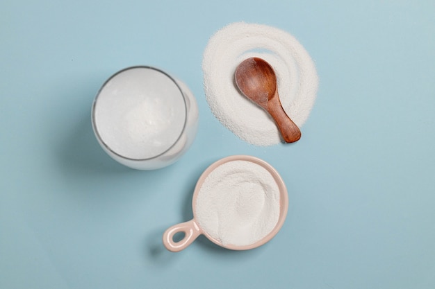 Collagen powder with wood spoon and glass of water