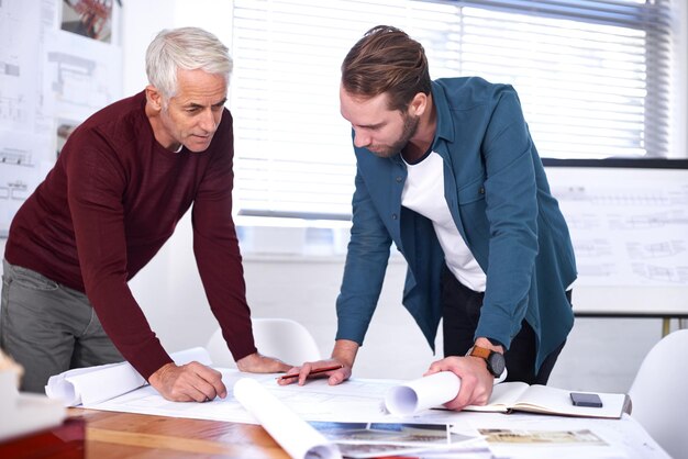 colleague men and blueprint with design at office with pencil for drawing a building renovation teamwork and project as architects business people and collaboration on task plan and layout draft
