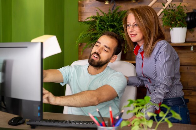 A colleague tells the boss something on the computer.In modern office