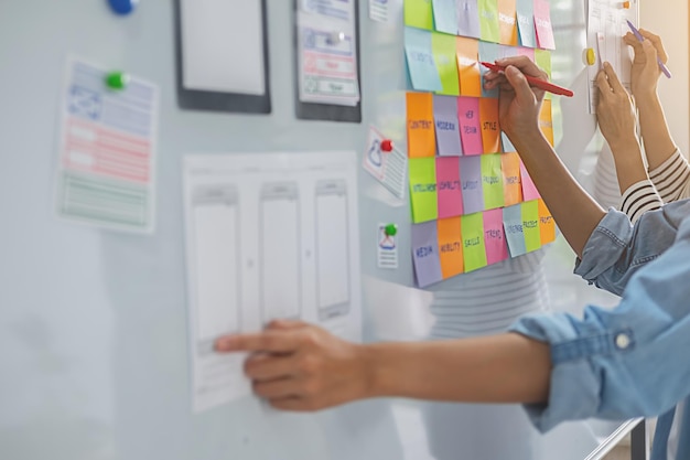 Colleagues discussing over adhesive notes