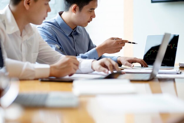 Colleagues discussing data over laptop on desk in office