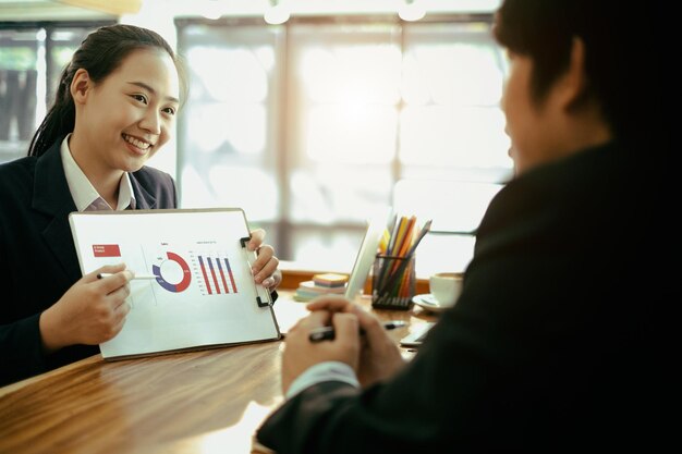 colleagues discussing over graph at desk in office