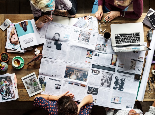 Colleagues discussing newspaper articles