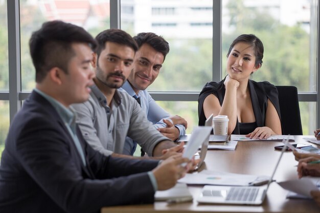 Photo colleagues discussing while sitting on table in office