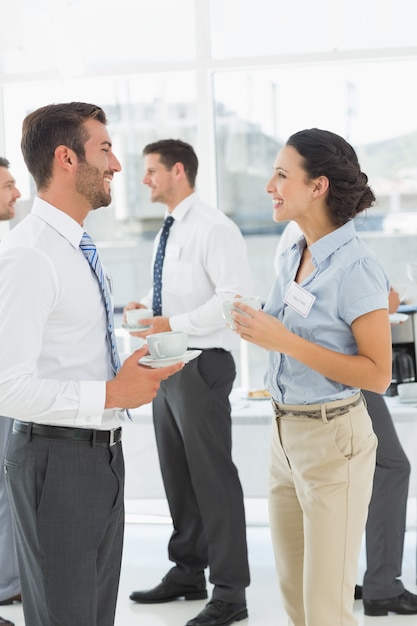 Colleagues in discussion with tea cups during break