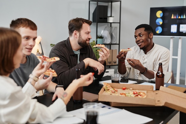 Colleagues eating pizza at office