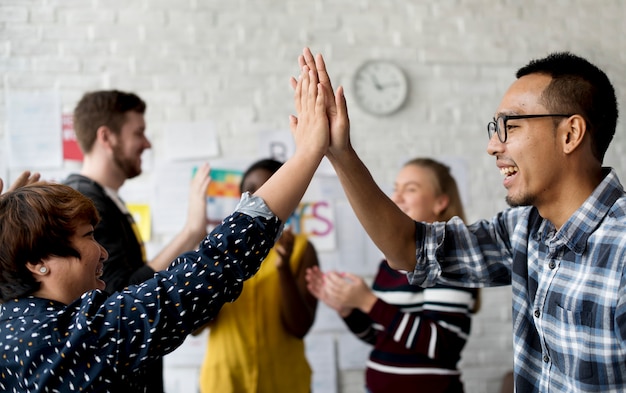 Photo colleagues hi-five in the office