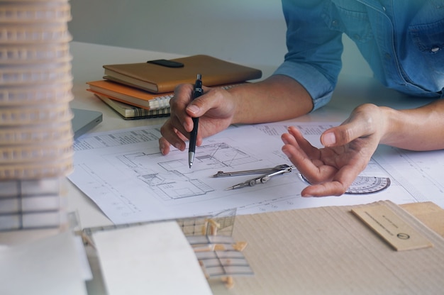 Colleagues interior designer corporate achievement planning\
design on blueprint teamwork concept with compasses.