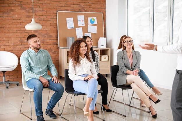 Colleagues listening to speaker at business meeting in office