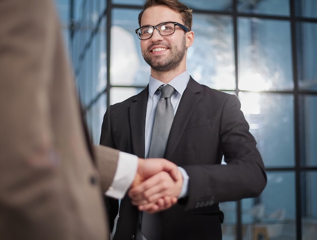 Colleagues shaking hands in the office lobby