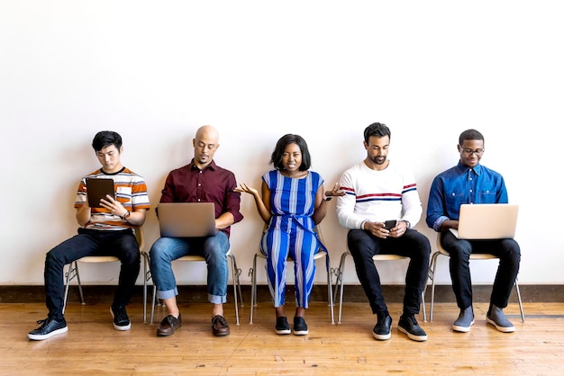 Colleagues sitting in a row using digital devices