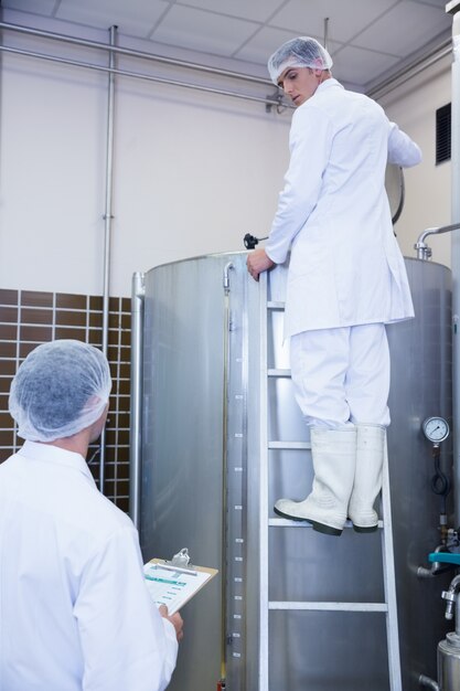 Colleagues speaking while on standing on the ladder