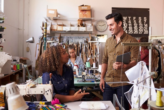 Colleagues talk at a clothes manufacturing studio close up