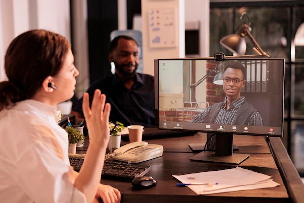 Photo colleagues talking on corporate online meeting using videocall app on computer, employees discussing business plan on videoconference. project manager speaking on teleconference briefing