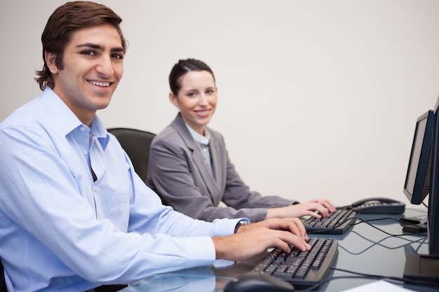 Colleagues using computers at office