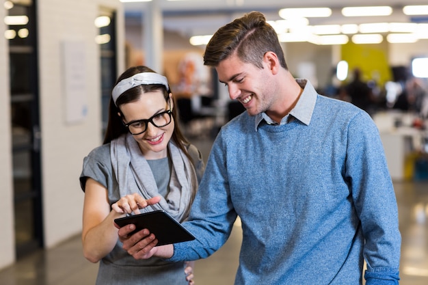 Colleagues using digital tablet in office