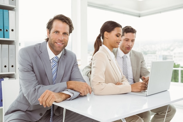 Colleagues using laptop in office