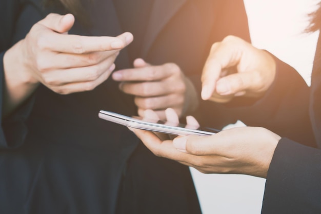 Colleagues using mobile phone in office