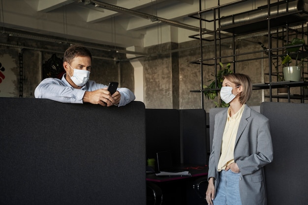 Photo colleagues wearing face masks medium shot