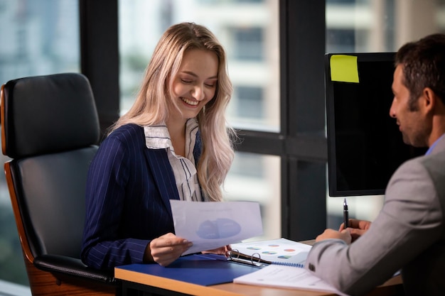 Colleagues working over graph at desk in office