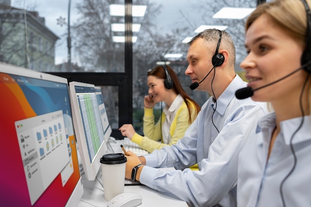 Photo colleagues working together in a call center with headphones