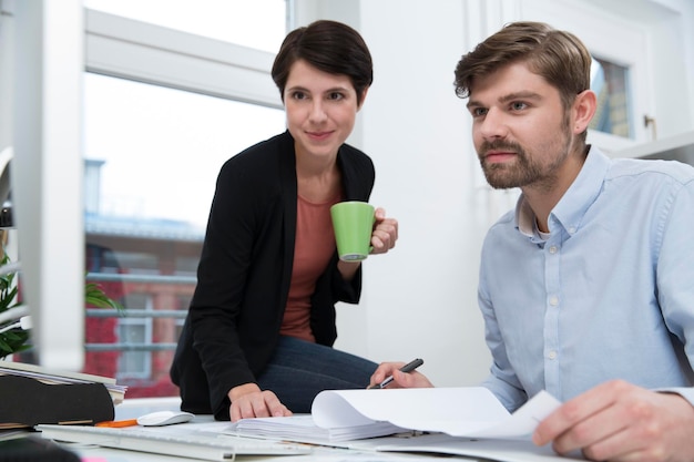 Colleagues working together at desk in office