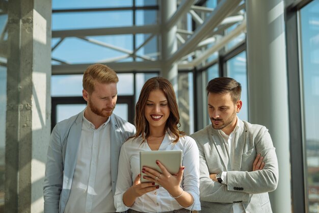 Colleagues working together on a tablet in an office.