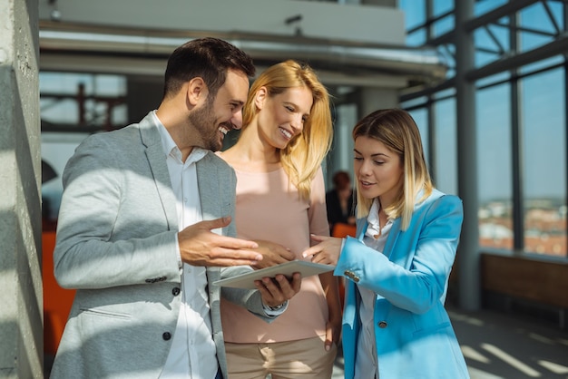 Colleagues working together on a tablet in an office.