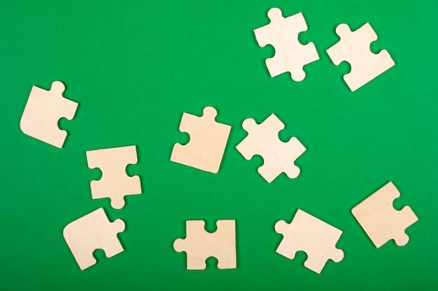 Collect puzzles. puzzle pieces scattered on a green background.