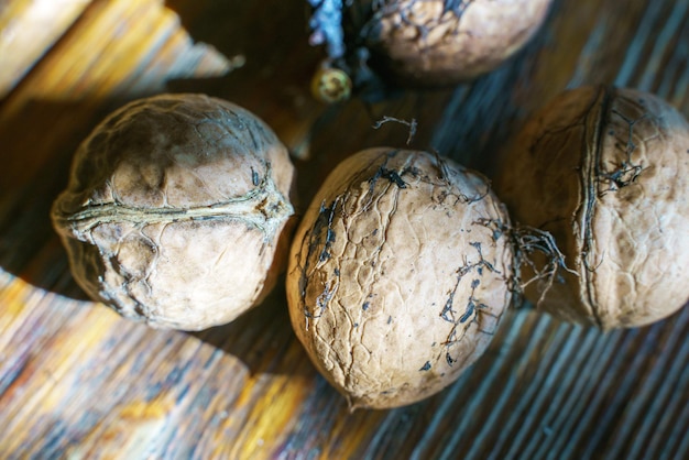 The collected walnuts lie on a wooden table the photo is fully revealed